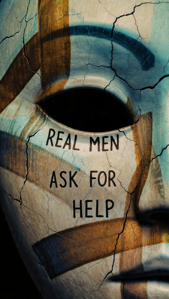 Photo of a sign that says “Real Men Ask for Help,” representing men’s mental health and the importance of vulnerability.
